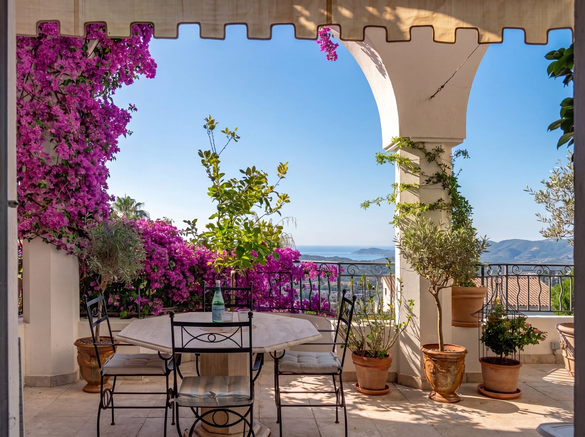 A vaulted terrace edged with bougainvillea, a table laid and the bay beyond