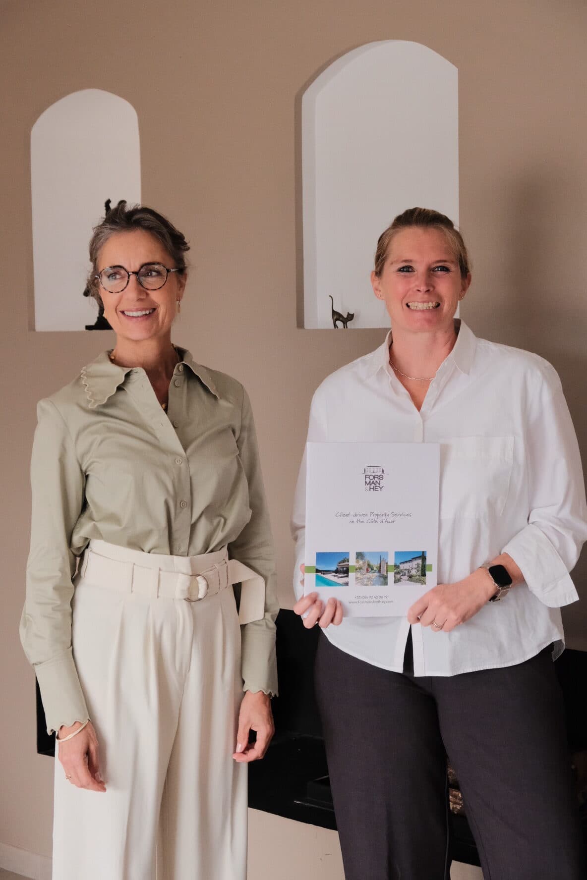 The Forsman & Hey team side by side, holding the presentation brochure