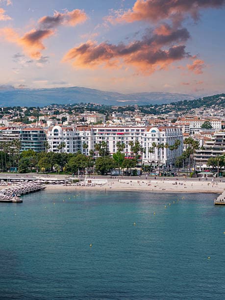 The Cannes seafront and its beach seen from the bay, backed by the hills inland