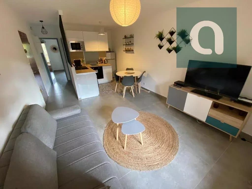 Salon moderne avec cuisine ouverte et décor minimaliste.